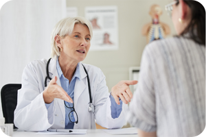 Ärztin im Gespräch mit einer Patientin im Behandlungszimmer.