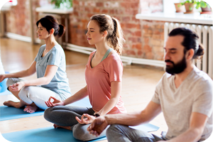 Gruppe von Menschen bei einer entspannenden Yoga- und Meditationsübung auf Matten.